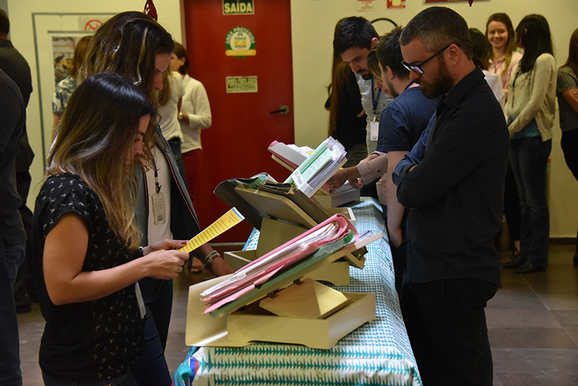 Visitantes conferindo o material da exposição