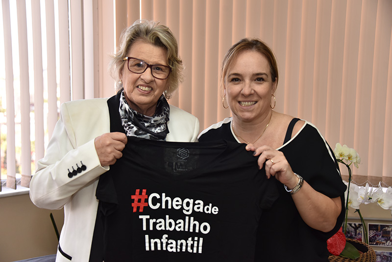 Fotografia da presidente do TRT-RS, desembargadora Vania Cunha Mattos, e da juíza convocada Silvana Tedesco, integrante do Comitê de Direitos Humanos e Trabalho Decente, segurando a camiseta de divulgação da campanha.