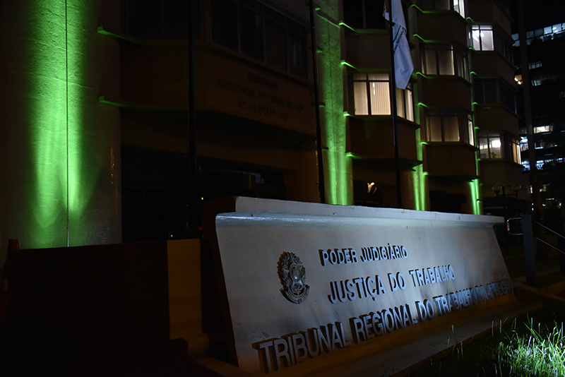 Fotografia do Prédio-Sede do TRT da 4ª Região com a fachada iluminada de  verde em alusão à campanha
