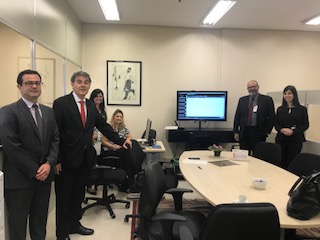 Fotografia de magistrados ao lado de mesa redonda do cejusc