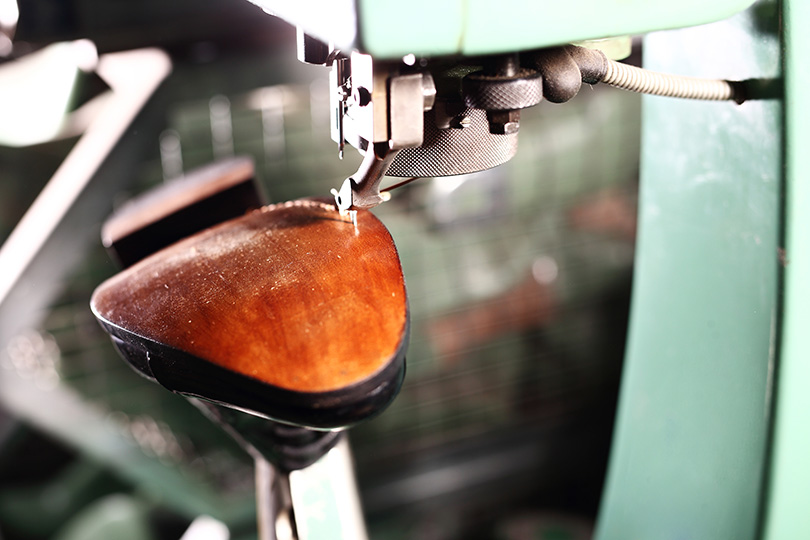 Foto de máquina costurando a sola de um sapato
