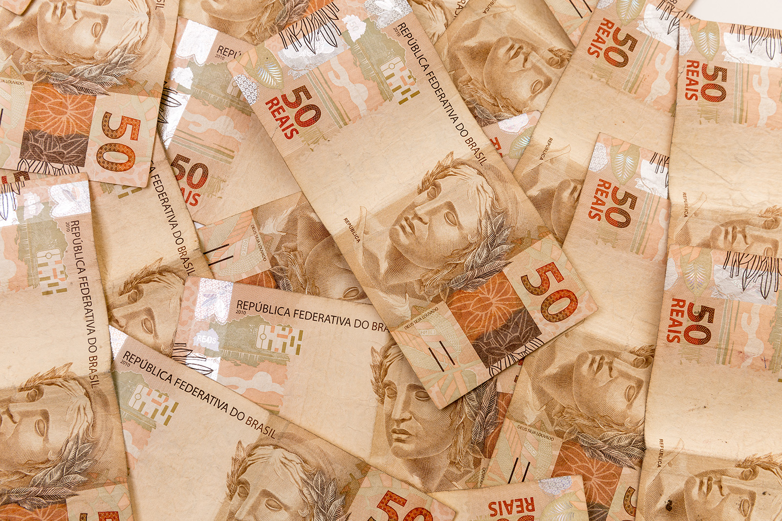Foto de notas de R$ 50 espalhadas em superfície plana