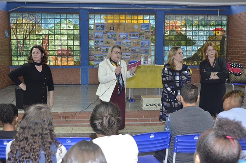 Foto das desembargadoras e a diretora da escola falando para os alunos