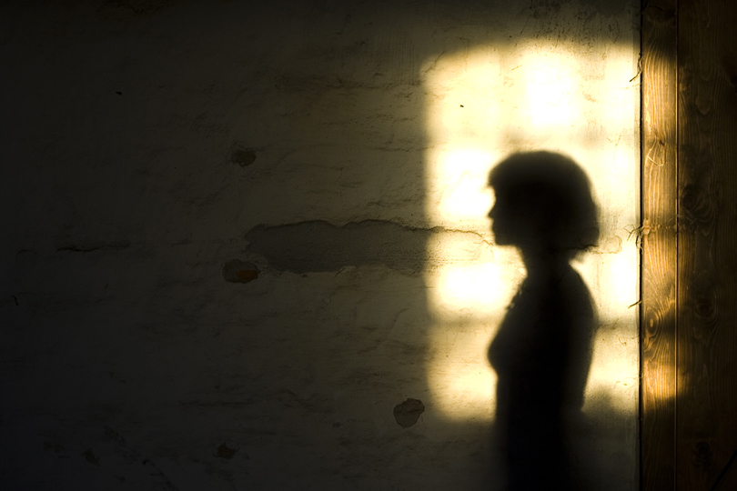 Sombra de uma mulher projetada na parede.