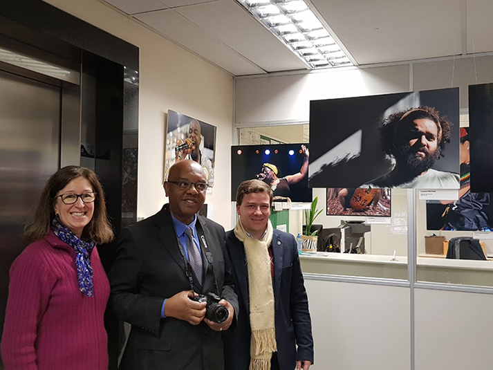 Fotógrafos em frente com algumas obras de fundo