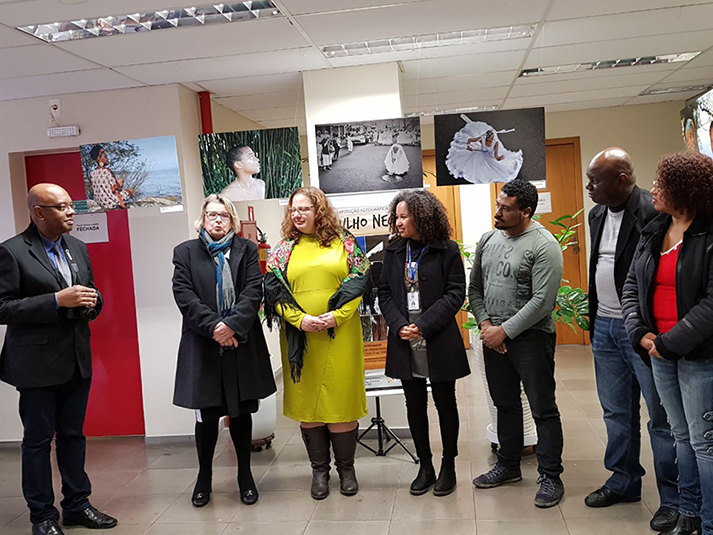 Foto posada com alguns fotógrafos e participantes, com a presença da presidente do TRT-RS, desembargadora Vania Cunha Mattos e algumas obras ao fundo