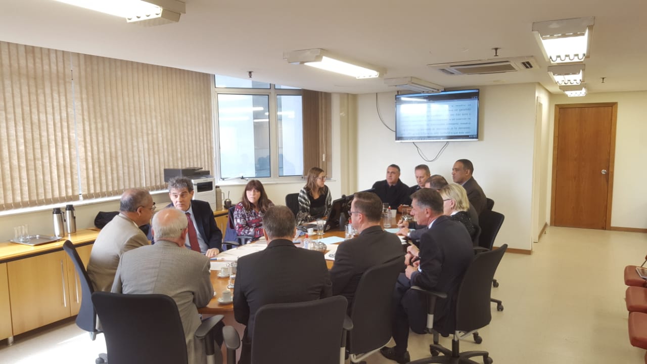 Sala de reuniões com a mesa em primeiro plano com representantes dos sindicatos e a Federação dos Metalúrgicos