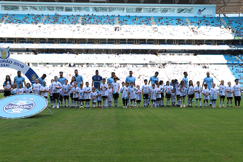 Seleção do Grêmio é acompanhada por crianças com a camiseta da campanha de Combate ao Trabalho Infantil