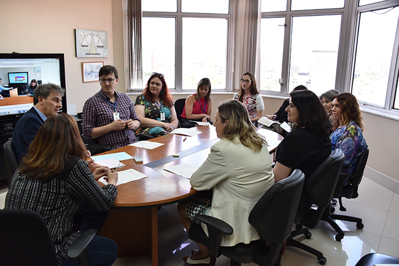 Participantes da reunião sentados à mesa.