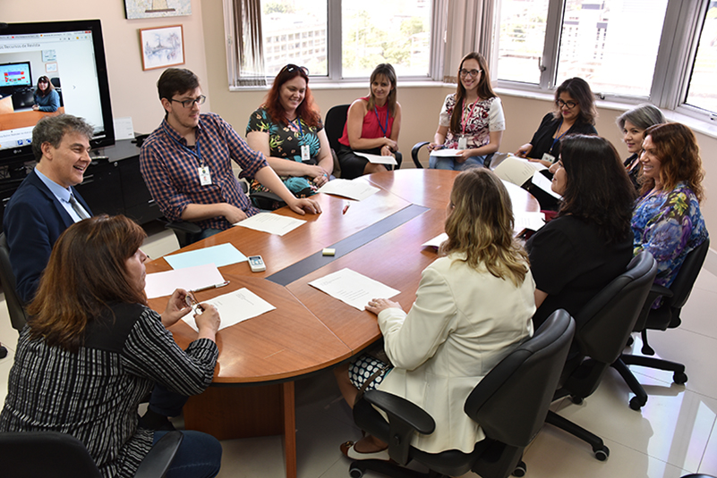 Participantes da reunião sentados à mesa.