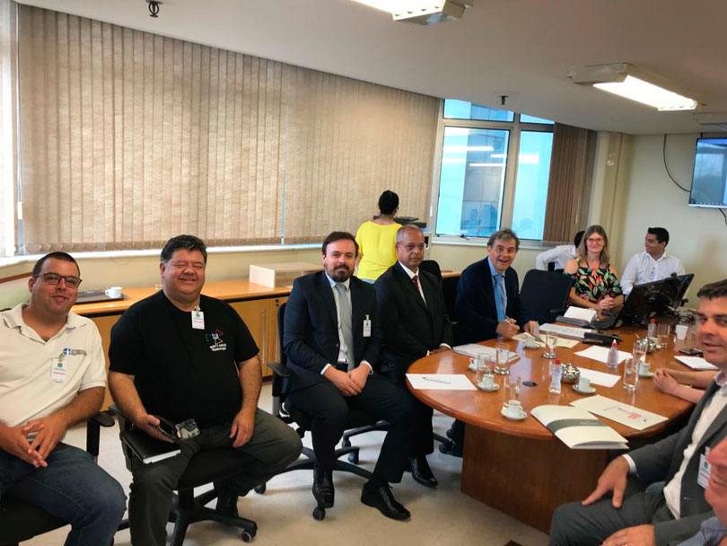 Imagem aberta da mesa de audiência, com participantes da reunião.
