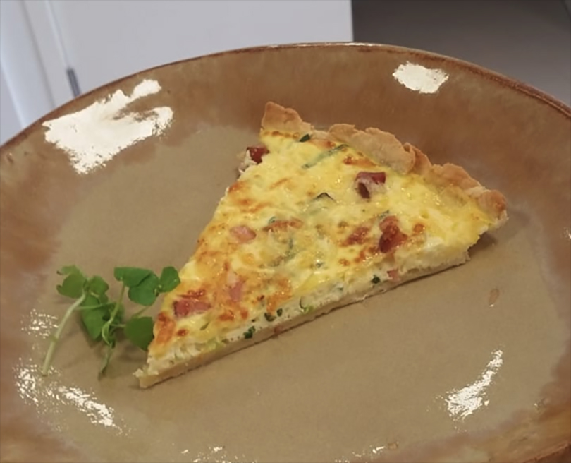 Foto de uma fatia triangular do Quiche Lorraine servido no prato