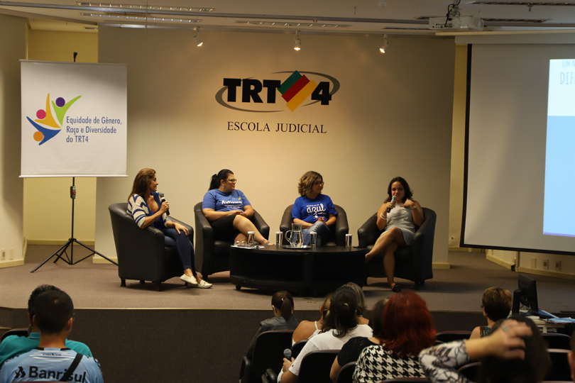 Imagem da roda de conversa, com as quatro participantes da atividade sentadas nas poltronas dispostas no palco