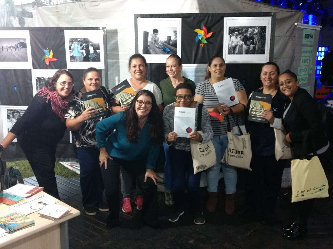 Foto posada de servidoras e visitantes no estande da Justiça do Trabalho, na 2ª Feira Literária de Taquara.