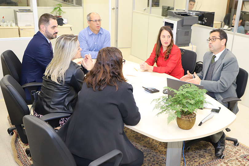 Imagem da audiência realizada no Cejusc, com os participantes sentados à mesa.