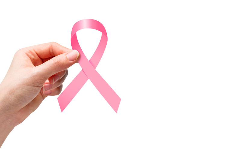 Imagem de uma mão feminina segurando uma fita rosa, símbolo do combate ao câncer de mama