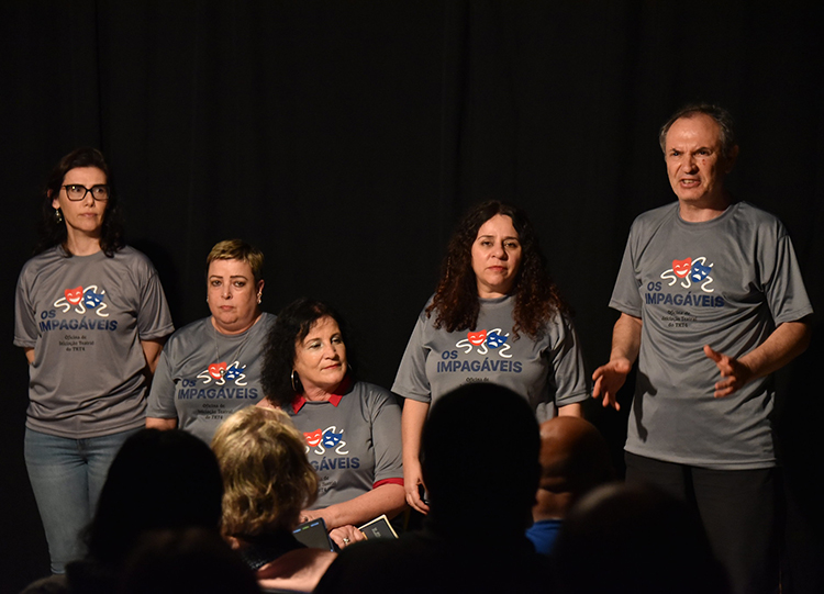 Foto de atores do grupo "Os Impagáveis" no palco, durante apresentação da peça.