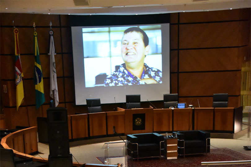Fotografia tirada no plenário, durante a exibição do documentário, exibido no telão.