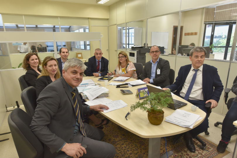 Foto dos participantes da audiência, sentados à mesa.