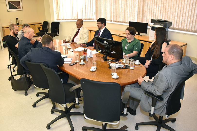 Foto da mesa de reunião em ângulo aberto, com participantes