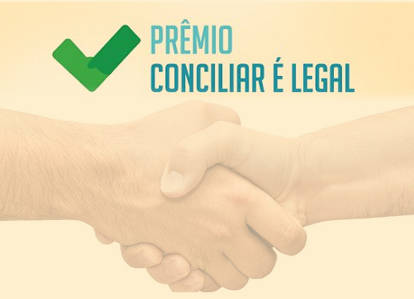 Logo do prêmio "Conciliar é Legal", com a foto de um aperto de mãos abaixo
