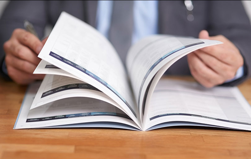 Imagem de um homem folheando uma revista.