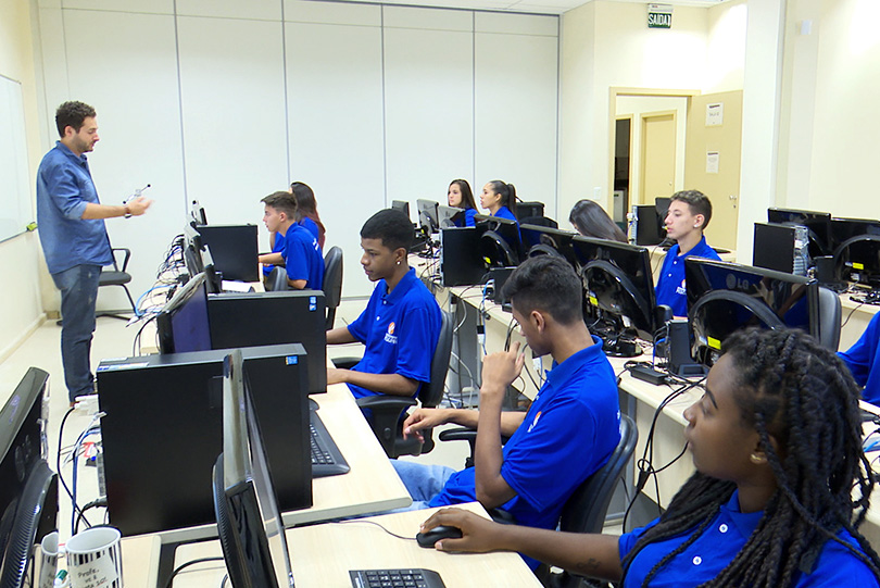 foto de alunos da turma 2018 do Projeto Pescar em uma sala, sentados em mesas com computadores e assistindo a uma aula