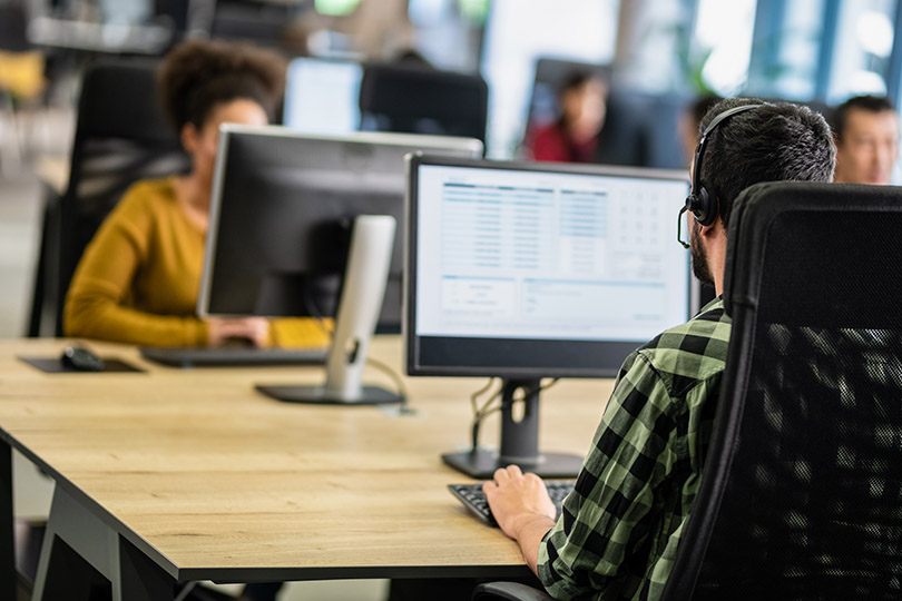 Pra Cego Ver: Foto de Tashi-Delek/iStock banco de imagens mostra trabalhadores de call center.