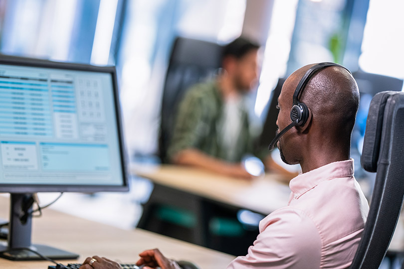 Pra Cego Ver: Foto de Tashi-Dlek/iStock Banco de Imagens mostra trabalhador de telemarketing.