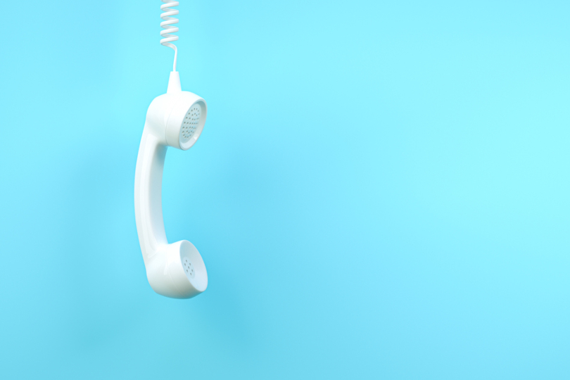 Ilustração de um telefone fixo com o fone pendurado