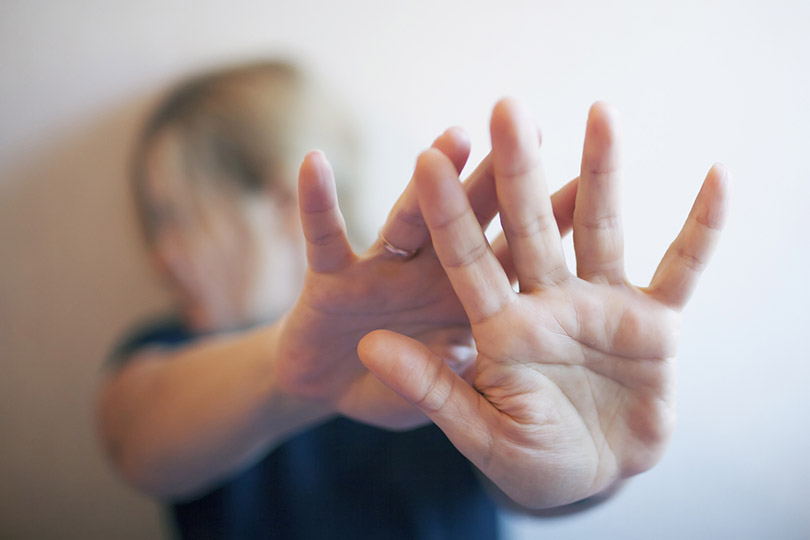 Pra cego ver: foto de Serghei Turcanu/iStock Banco de Imagens mostra mulher com as mãos esticadas, dando a ideia de afastar um agressor