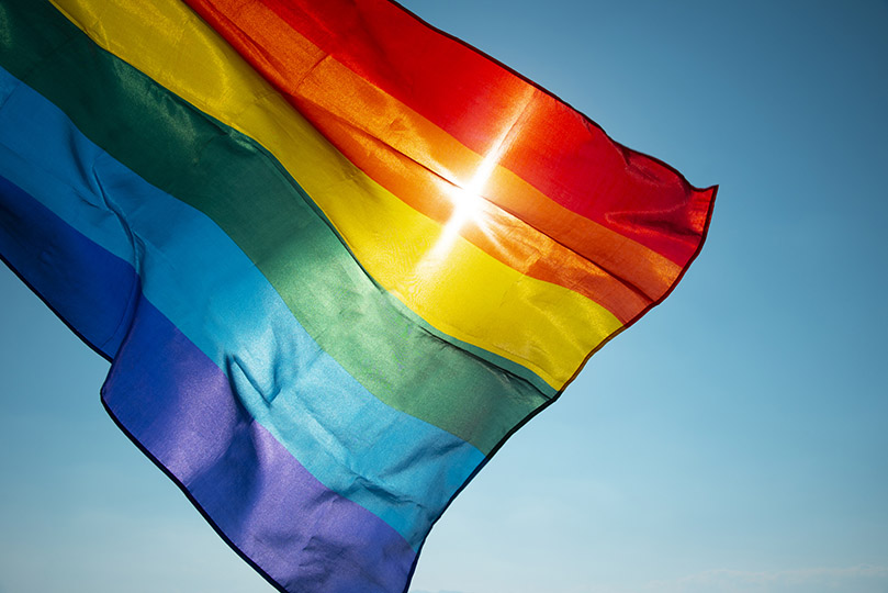 Pra Cego Ver: foto de nito 100/iStock Banco de Imagens mostra a bandeira LGBTI+, com as cores do arco-íris