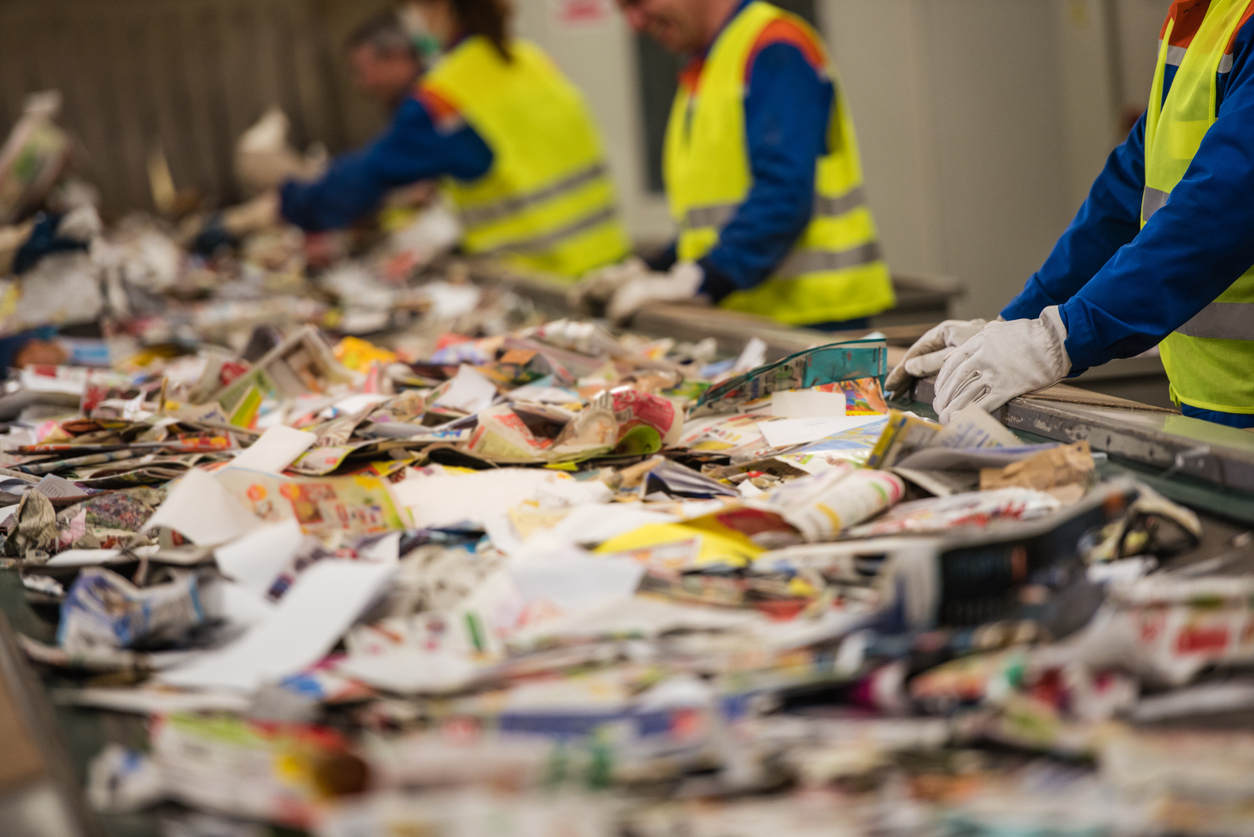 Foto de trabalhadores com luvas em um centro de reciclagem