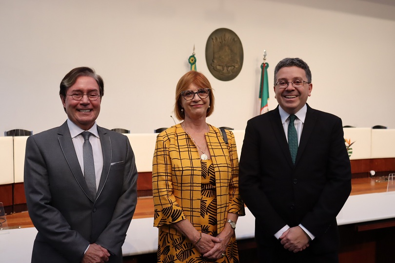 Foto da desembargadora Telesca ao lado do defensor público-geral e outra autoridade presente na cerimônia.