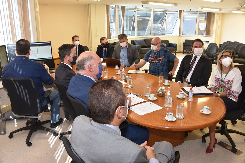 Foto da audiência, mostrando os participantes sentados à mesa de reunião.
