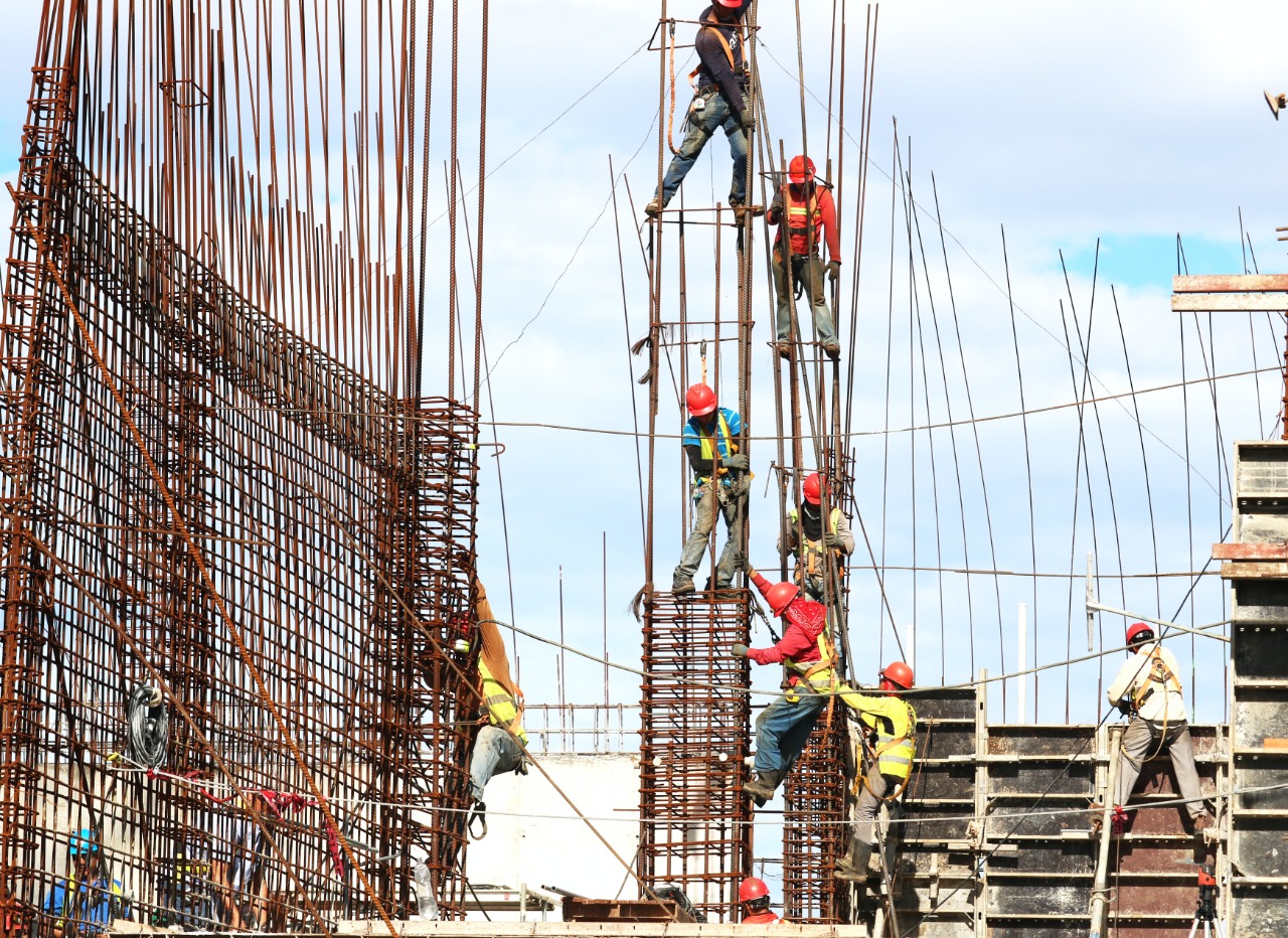 Foto mostra operadores em uma obra de construção em situações inadequadas de trabalho