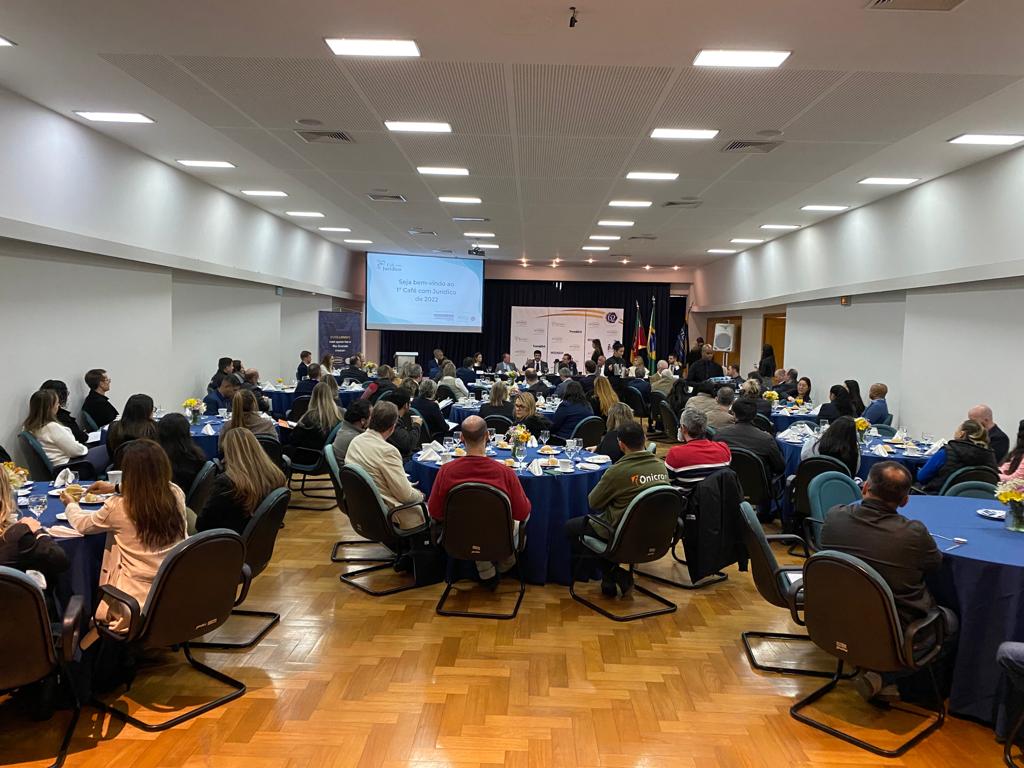 Foto em ângulo aberto, mostrando o público nas mesas.