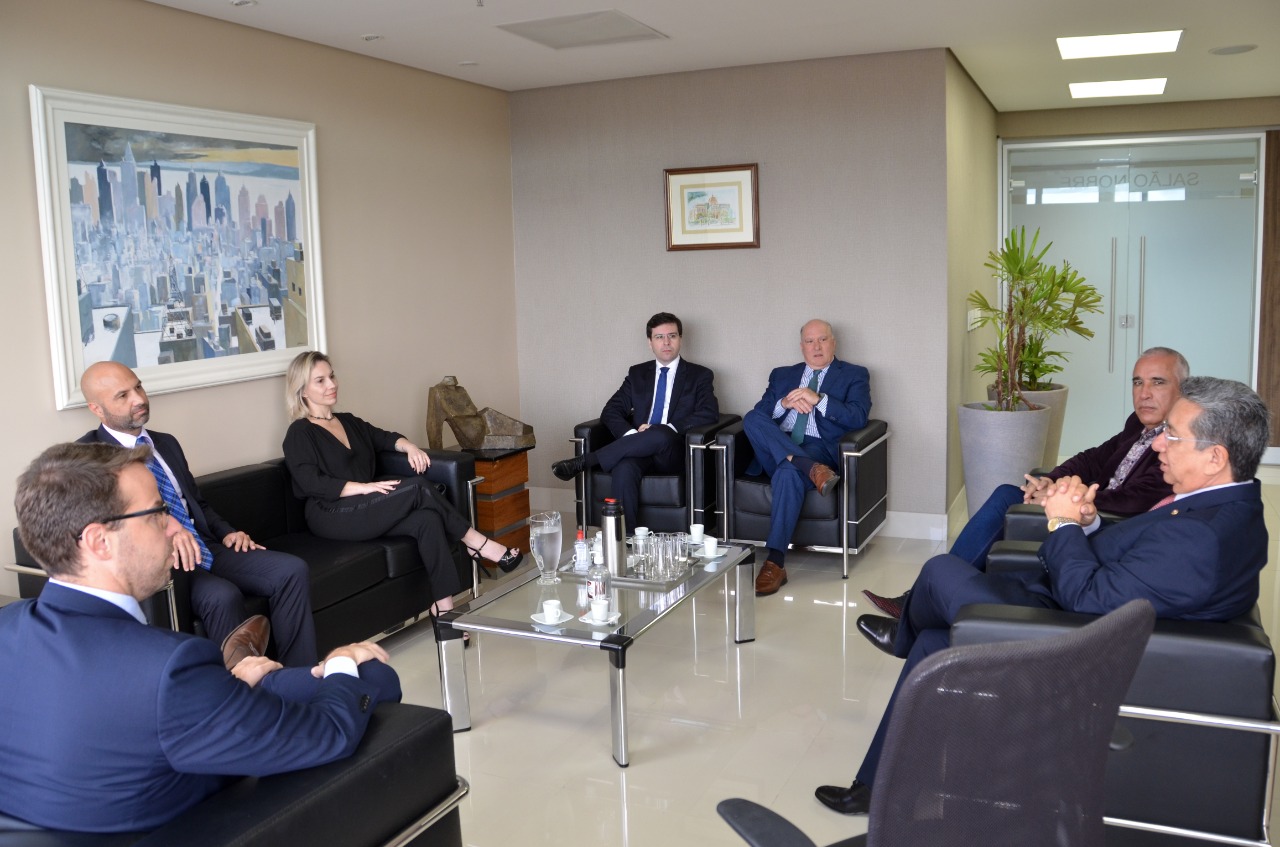 Foto dos participantes da reunião conversando, sentados em sofás dispostos em um círculo.