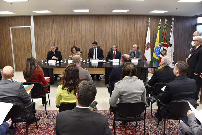 foto em ângulo aberto da reunião, mostrando mesa oficial e parte do público