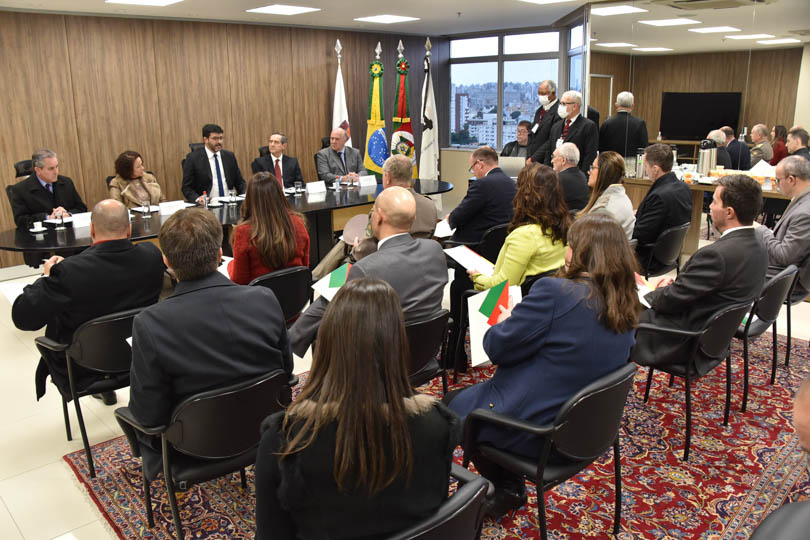 foto em ângulo aberto da reunião, mostrando mesa oficial e parte do público