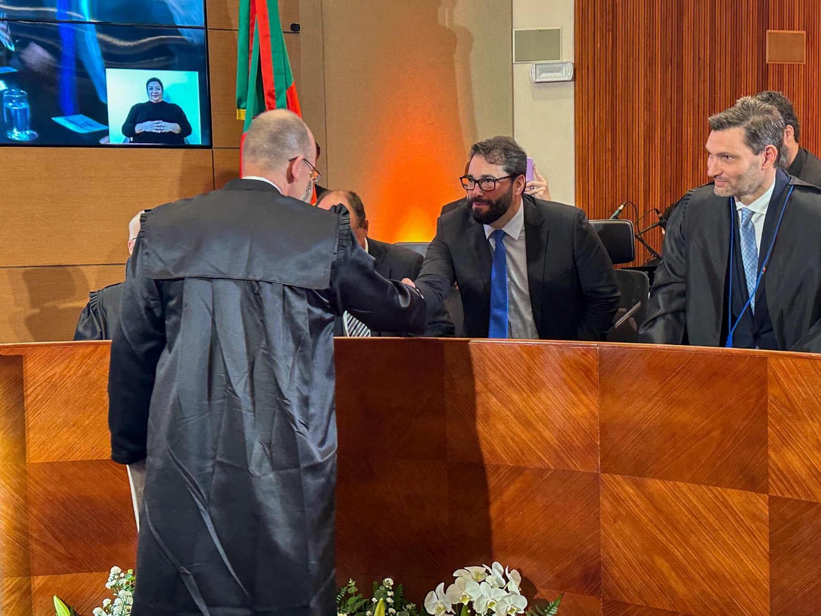 A foto Alexandre cumprimentando desembargador.