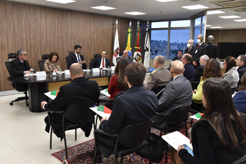 foto em ângulo aberto da reunião, mostrando mesa oficial e parte do público