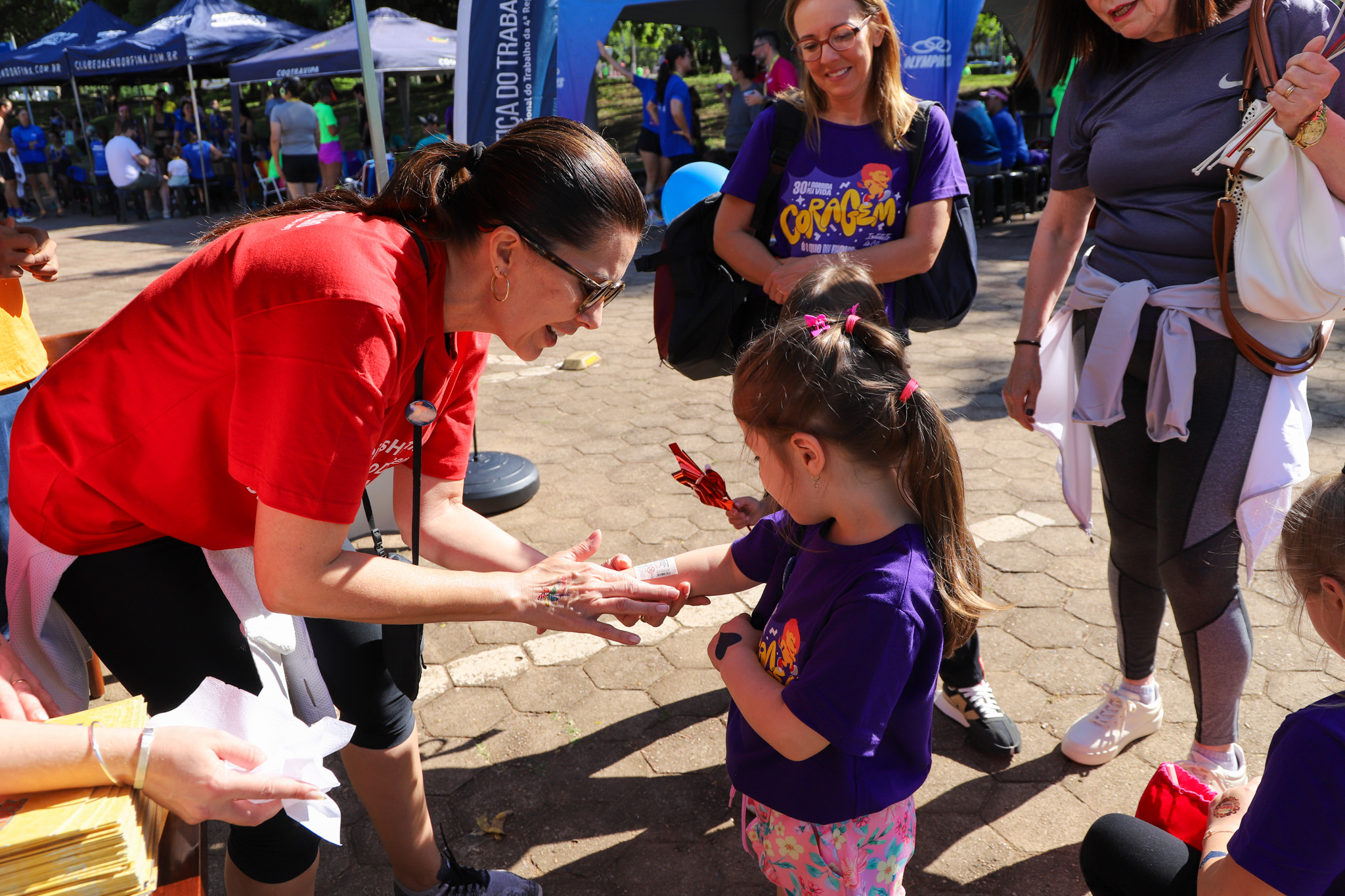 Juíza Aline aplica tatuagem em criança no estante do TRT-RS na Maratona