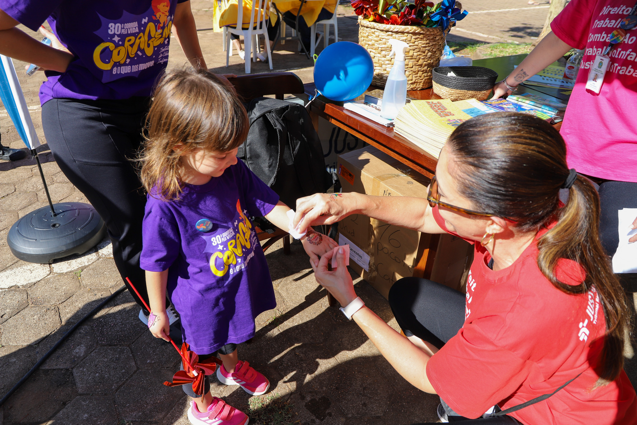 Juíza Aline aplica tatuagem em criança no estante do TRT-RS na Maratona