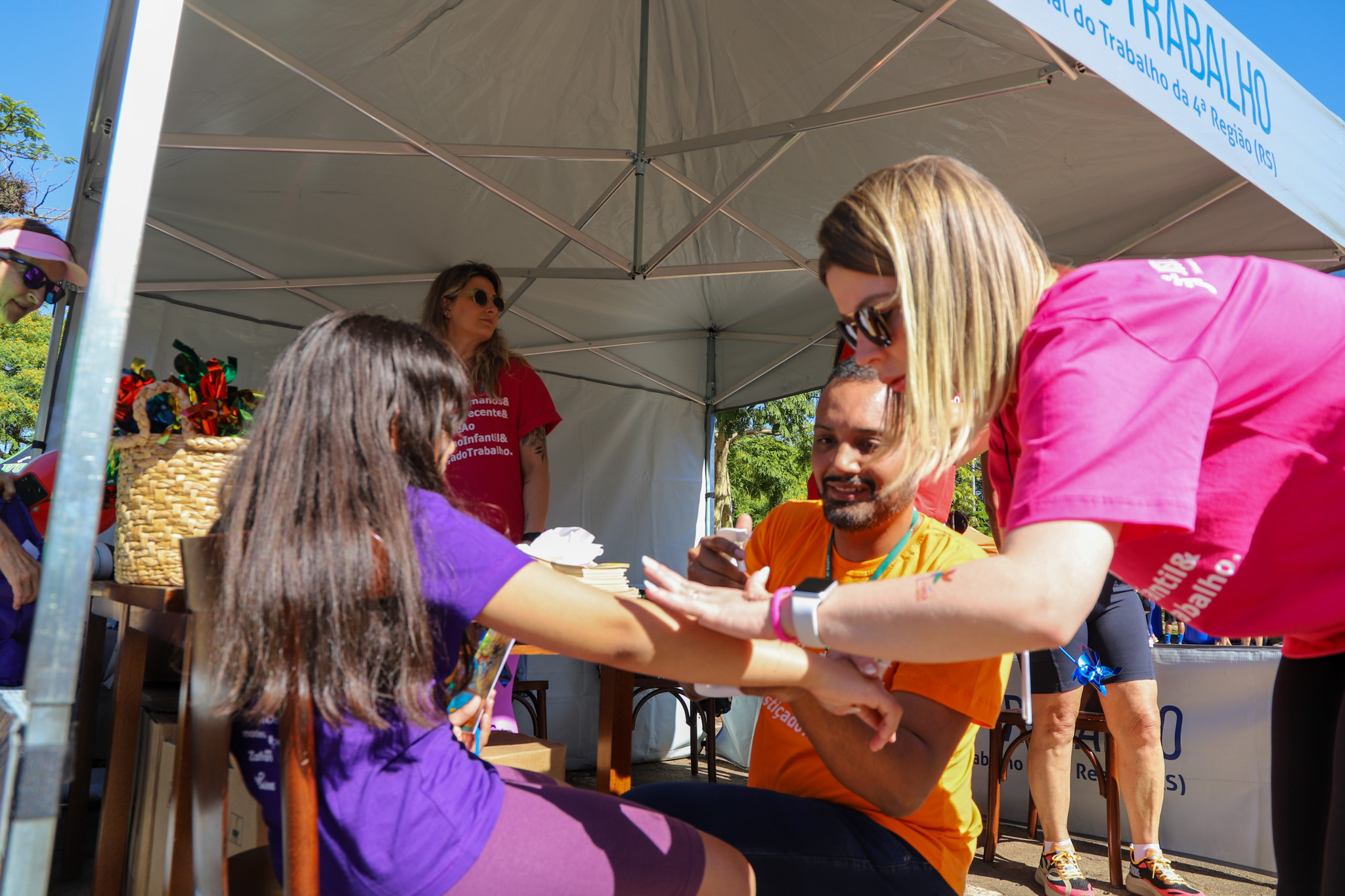 Servidor e servidora do TRT-RS aplicam tatuagem em criança maratonista