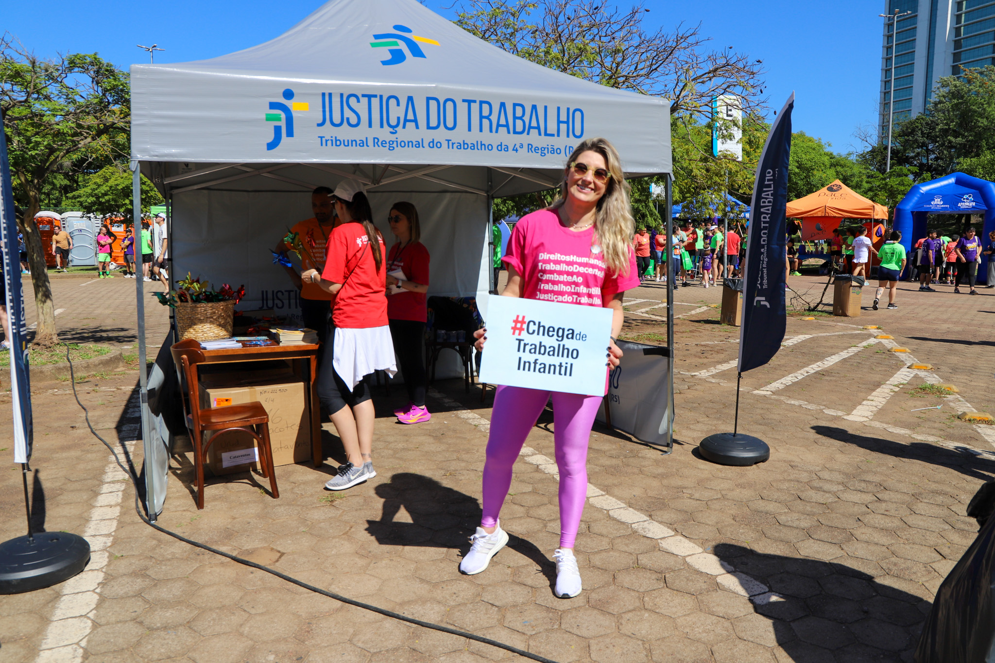 Servidora do TRT-RS posa com o cartaz #chega de trabalho infantil