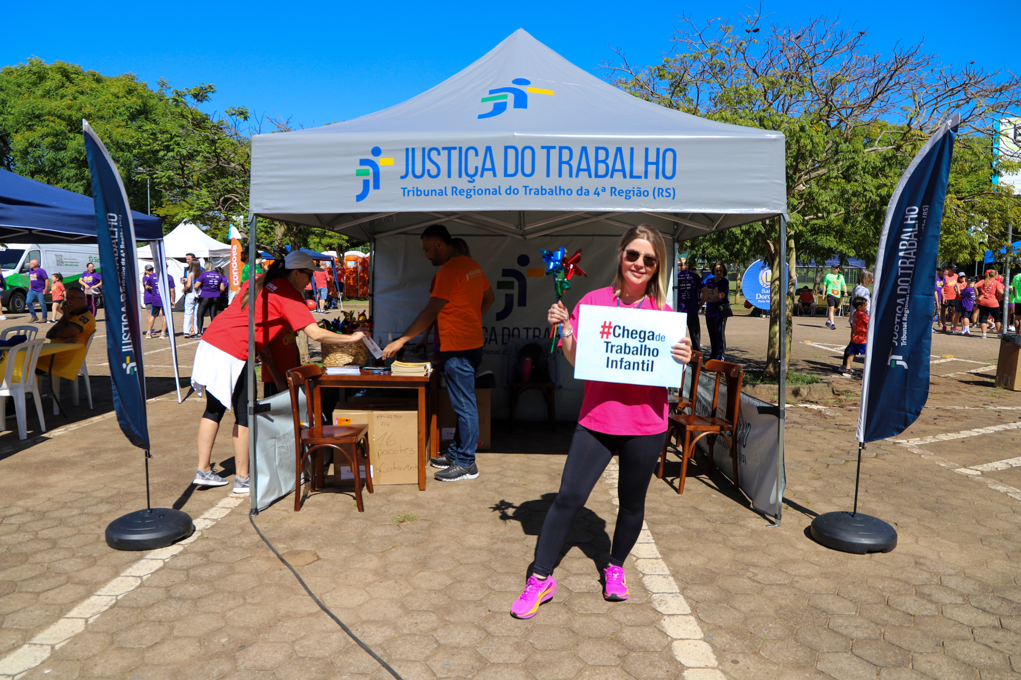 Servidora do TRT-RS posa com o cartaz #chega de trabalho infantil