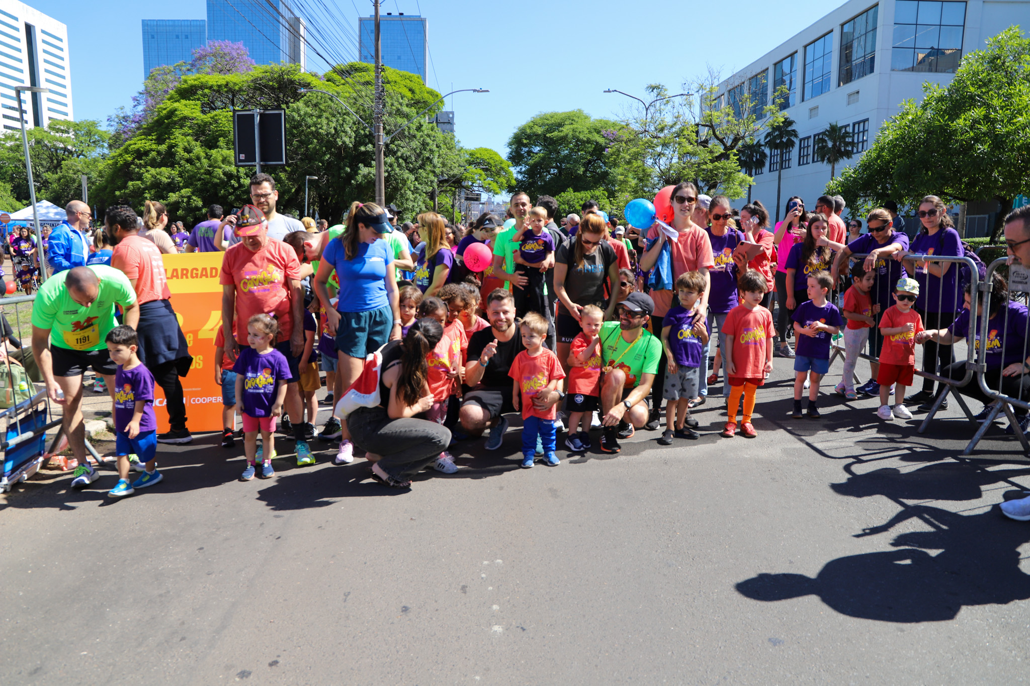 Crianças maratonistas posam para fotos com seus pais.