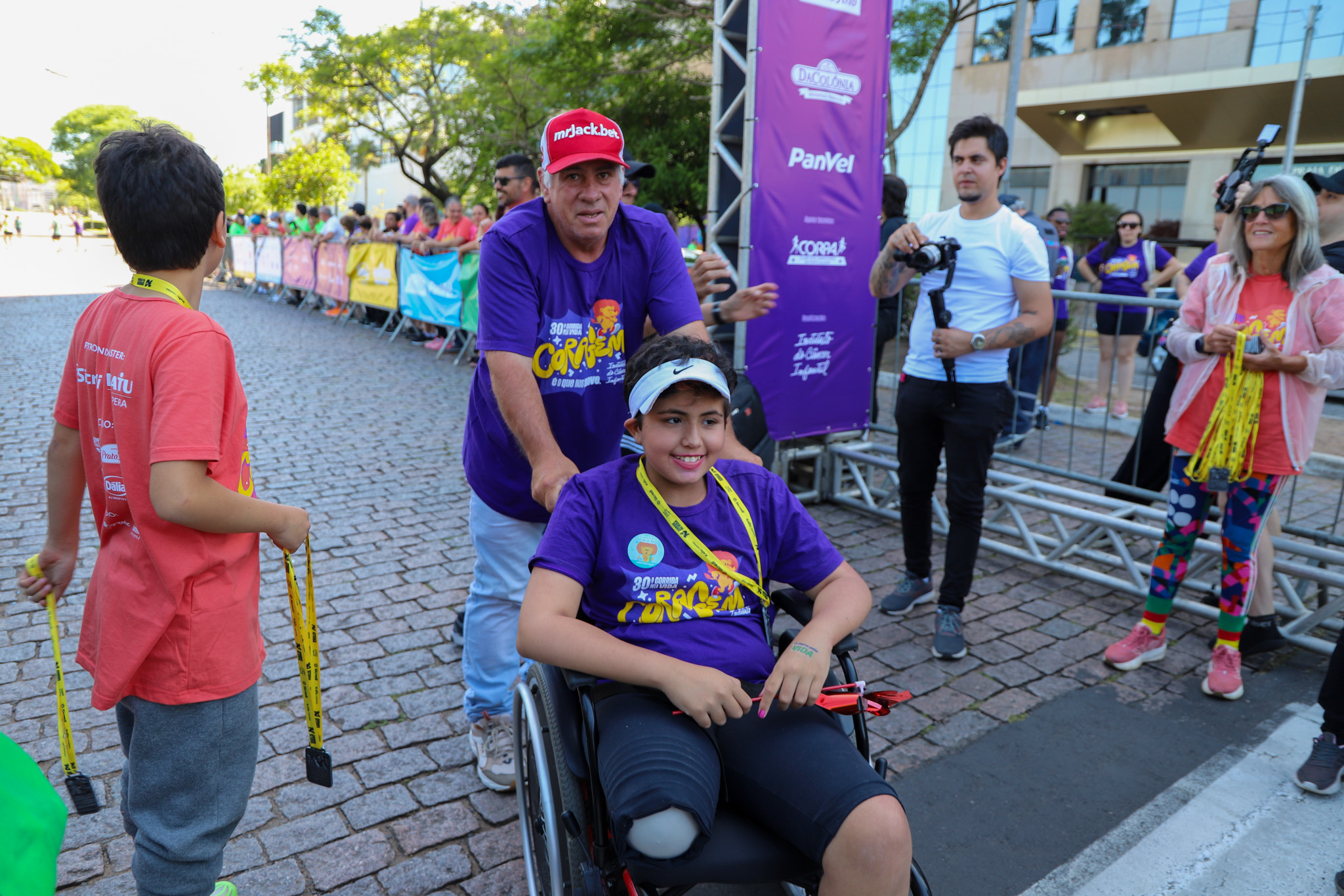 Participante em cadeira de rodas na corrida infantojuvenil.