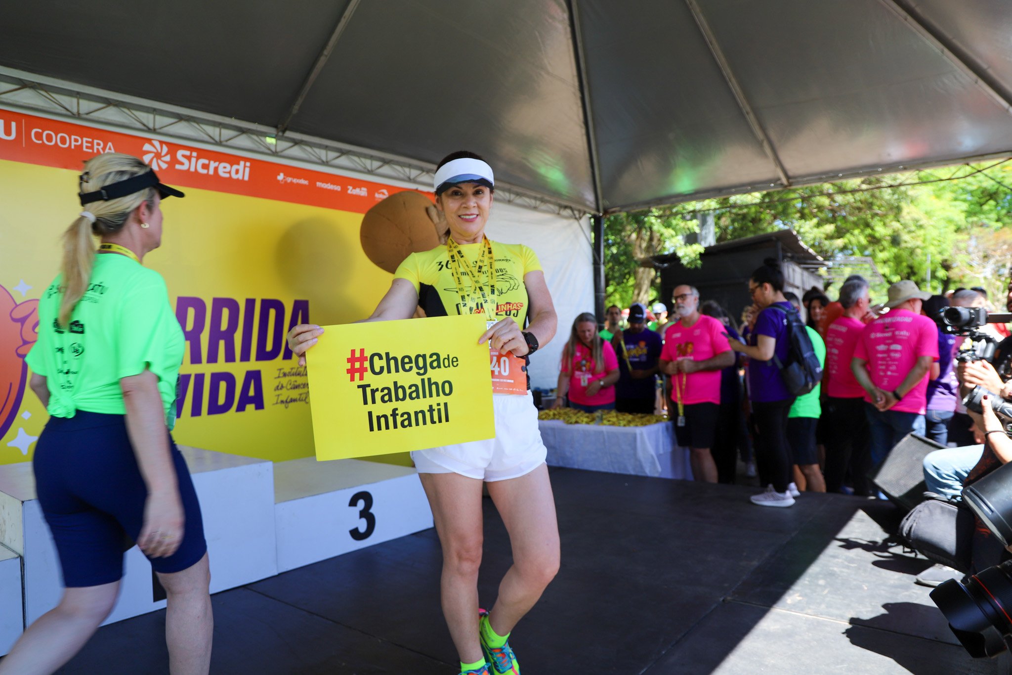 Corredora da Maratona posa com o cartaz #chega de trabalho infantil.